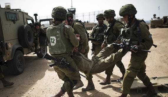 Israeli soldiers carry their comrade during a military exercise in the region bordering the Gaza Strip, southern Israel