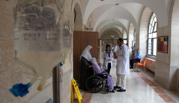 Doctors speak to a Palestinian patient at Augusta Victoria Hospital in East Jerusalem