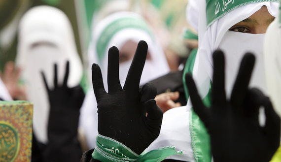 Palestinian students supporting Hamas flash three fingers to draw attention to their electoral number during an election campaign for students’ council at Palestine Polytechnic University in Hebron