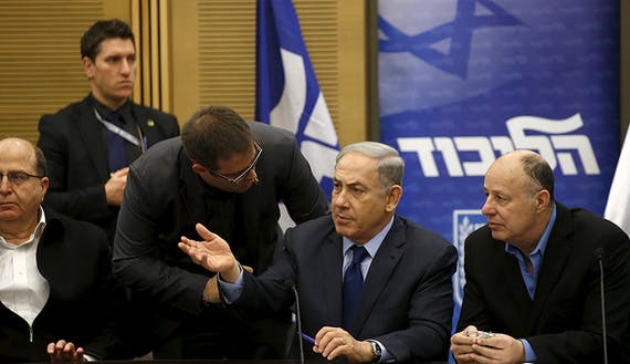 Israel’s Prime Minister Benjamin Netanyahu chats with members of his Party during a meeting in the Israeli parliament in Jerusalem