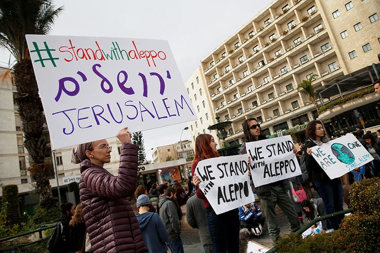 Israeli protesters hold placards during a demonstration to show solidarity with the citizens of Aleppo, Syria, outside the prime minister’s residence in Jerusalem
