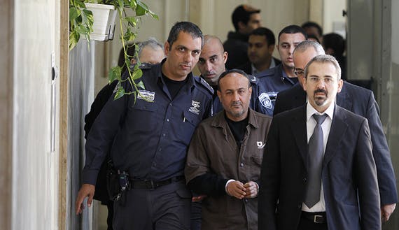 An Israeli prison guard escorts Barghouti to a deliberation at court in Jerusalem