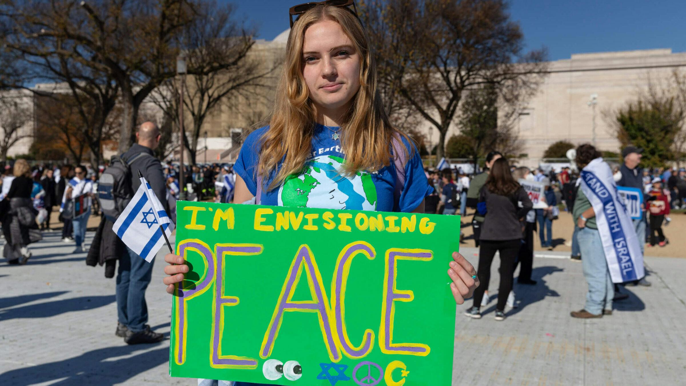 Young woman holding a sign reading 'I'm envisioning peace'.