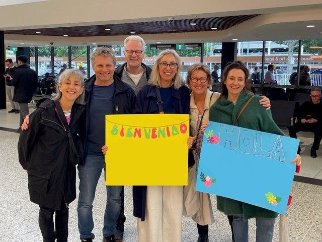 Six adults smiling and holding welcome signs
