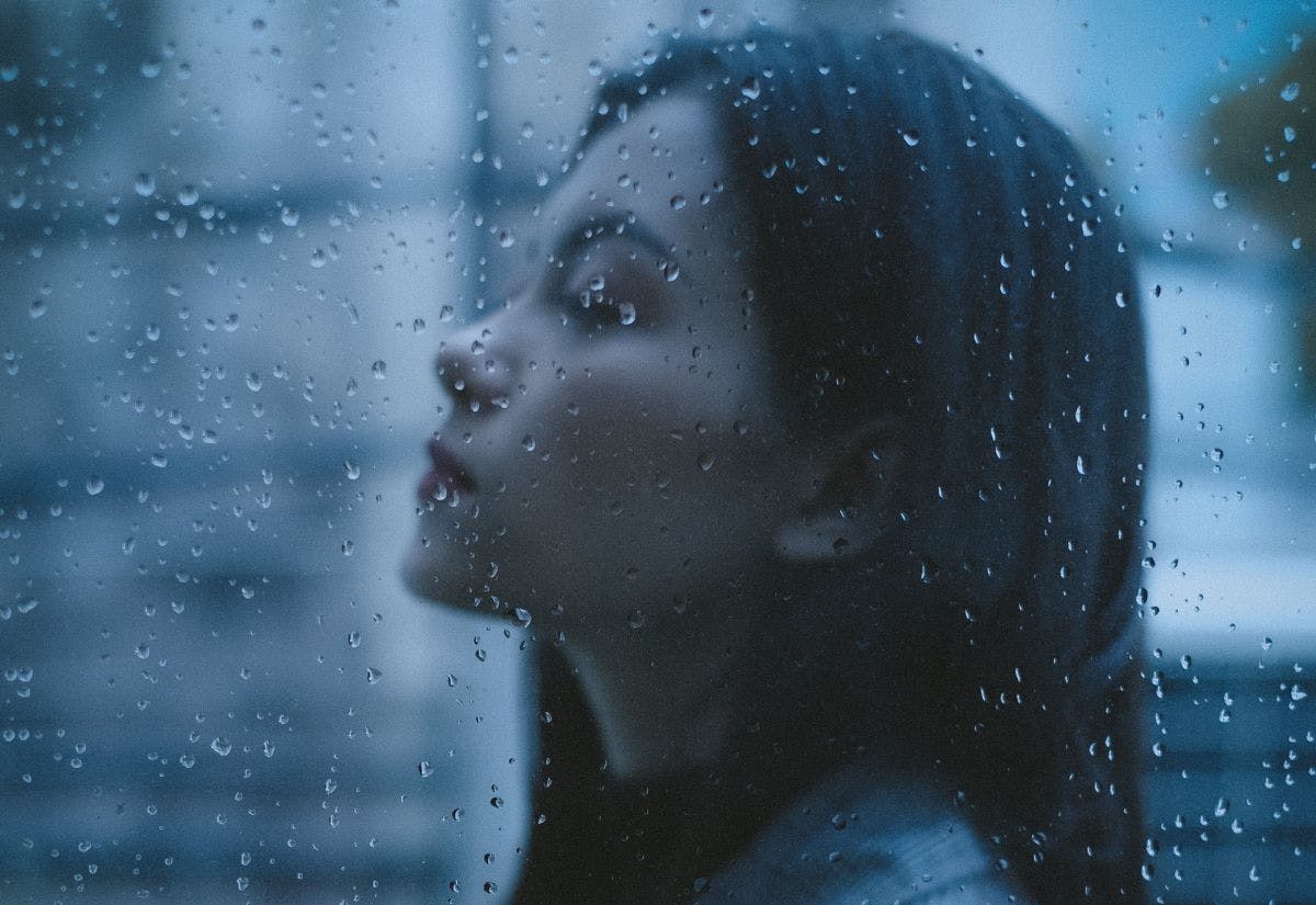 Woman with eyes closed in the rain