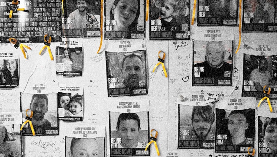 Wall with posters of hostages and yellow ribbons