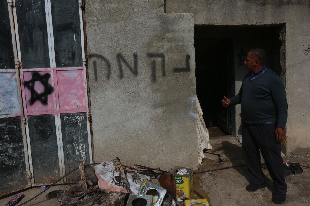 Damaged house with a star of David and Hebrew grafitti