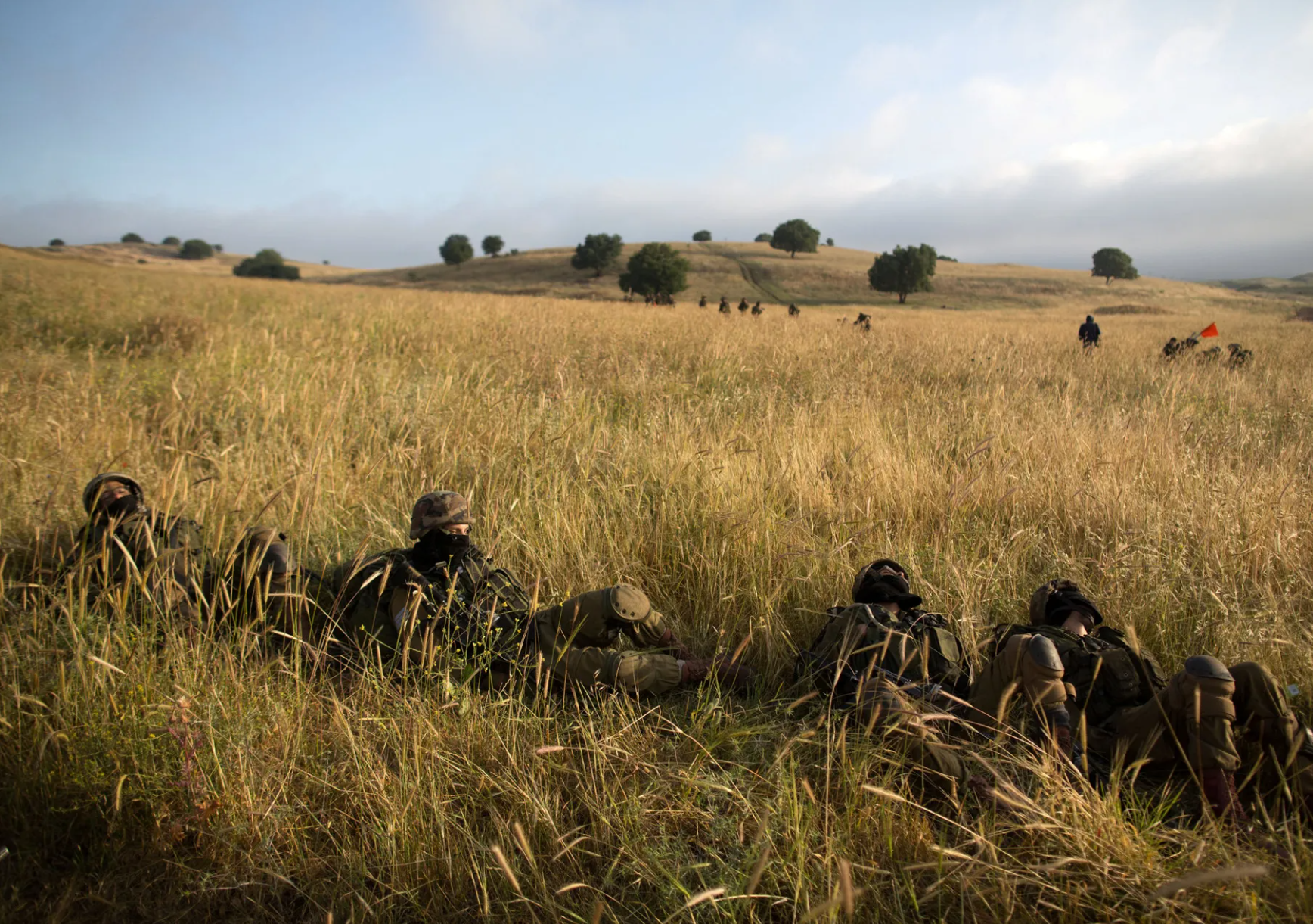 Soldiers lying in long yellow grass