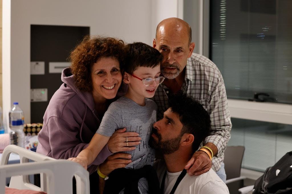 boy being hugged by family members
