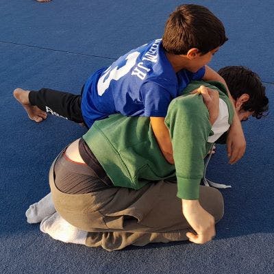 Sam Stein on the wrestling mat with a Palestinian student