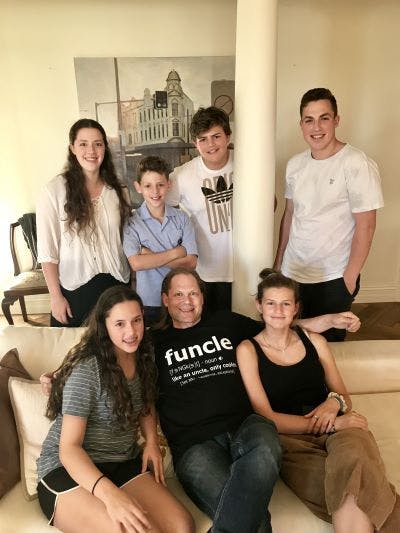 Shaun Miller, with his nieces and nephews, in a T-shirt celebrating his status as a "fun uncle" (supplied)