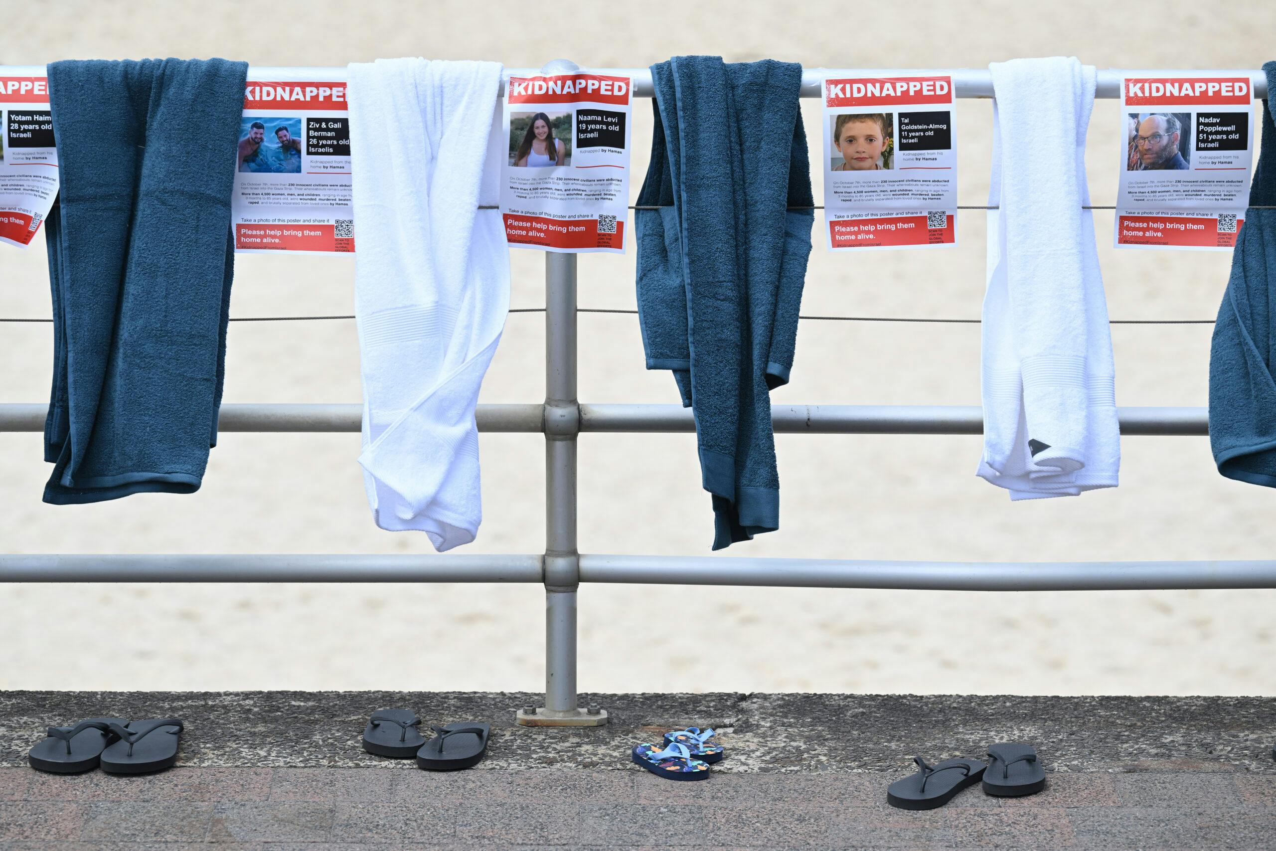 An installation of beach towels and thongs along side posters showing those kidnapped in support of the Global #BringThemHome Campaign at Bondi Beach in Sydney, Thursday, November 2, 2023.