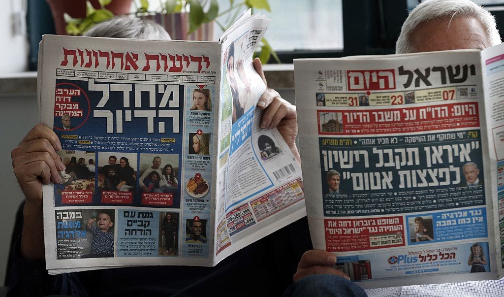 Men reading Hebrew newspapers