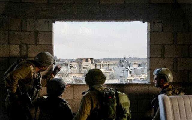 soldiers looking through a gap in a wall to a city