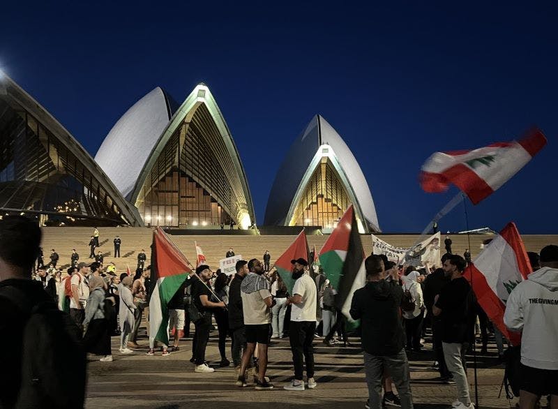 People with Palestinain flags in front of the Sydney Opera House