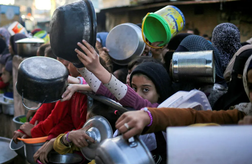 A crowd of children with empty dishes