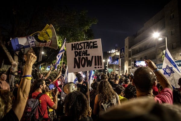 Protester holds a placard outside Benjamin Netanyahu's residence (Eyal Warshavsky/SOPA)